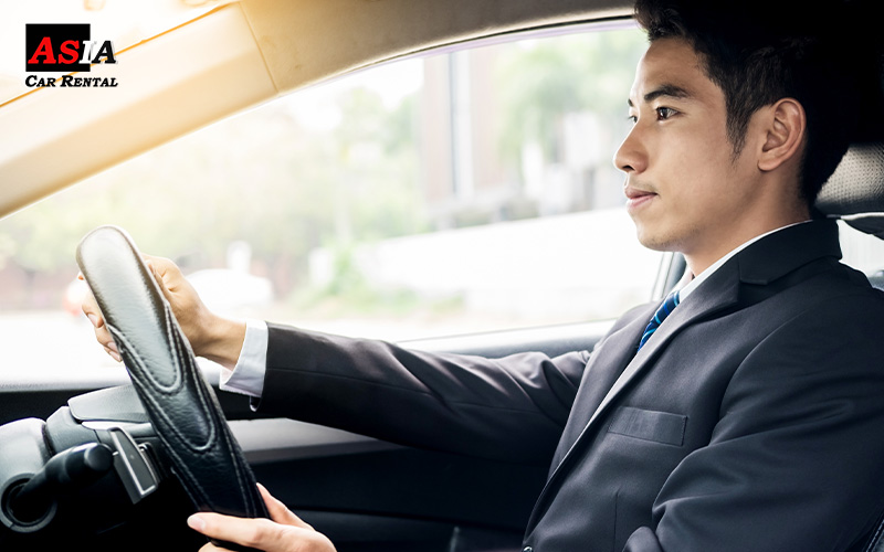 a businessman driving a rental car