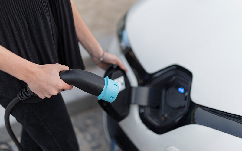 Person-plugging-charger-into-electric-car-at-Singapore-charging-station